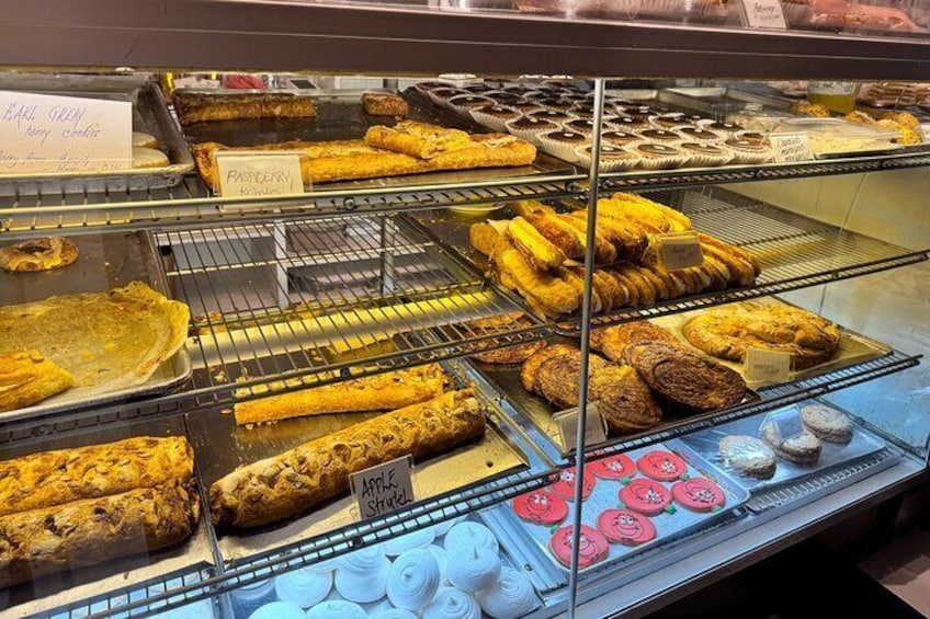 A bakery display case with various baked goods like pies, pastries, and cookies. 2