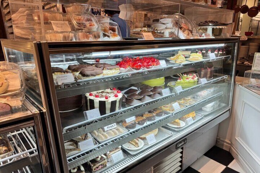 A bakery display case with various cakes and pastries. 3