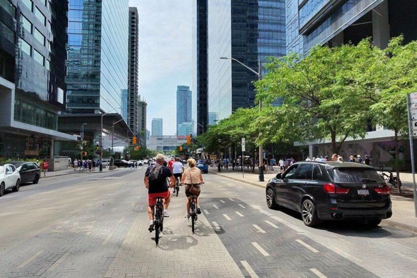 Een stadstraat met fietsers, auto's en hoge gebouwen. 5