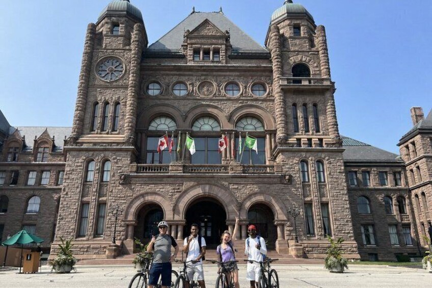 A historic stone building with arched windows and a clock tower. 4