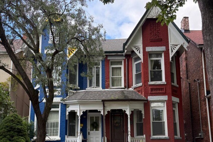A row of colorful Victorian-style houses with distinct red, blue, and white facades. 5