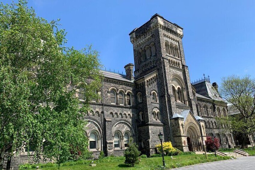 A historic stone building with arched windows and a prominent tower. 5