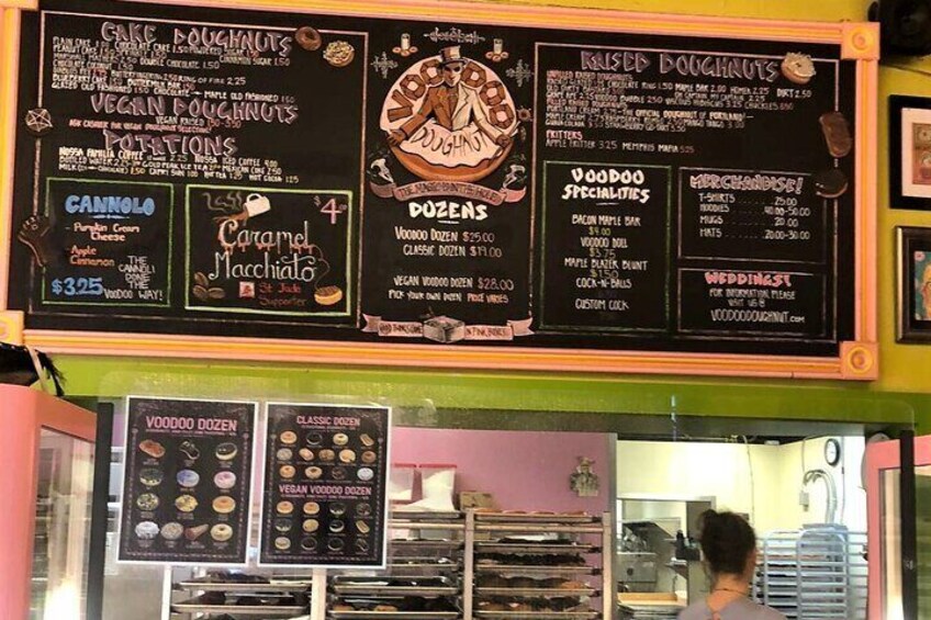 A menu board with various doughnut options and prices. 3