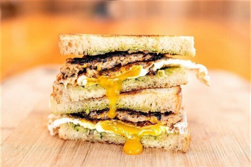 A grilled sandwich with visible layers of ingredients. 1