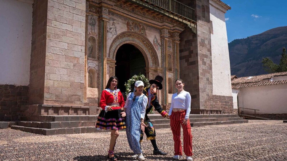 A group of people in front of a historic building with an ornate archway and a mountain in the background. 2