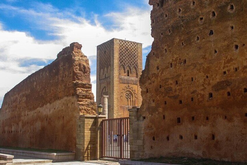 A historic building with a large arched doorway and a tall tower with intricate patterns. 5