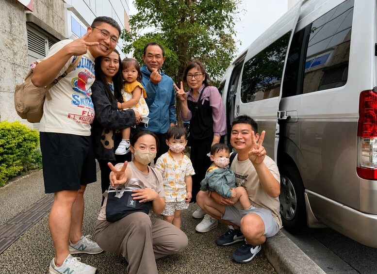 A group of people posing in front of a parked van. 4