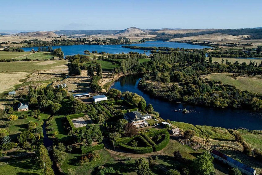 A riverside estate with a large house, a tennis court, and a lake. 4