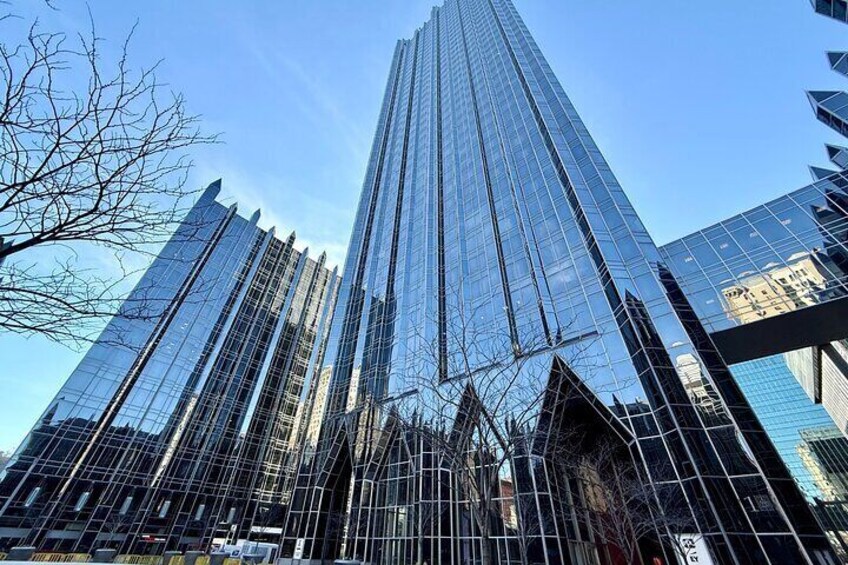 A tall glass skyscraper with a clear blue sky in the background. 3