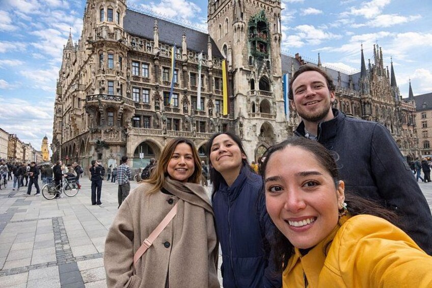 A historic building with intricate architecture, a group of people in front, and a clear sky. 1