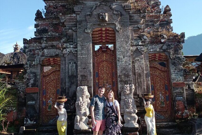A temple with ornate red doors and stone statues. 2