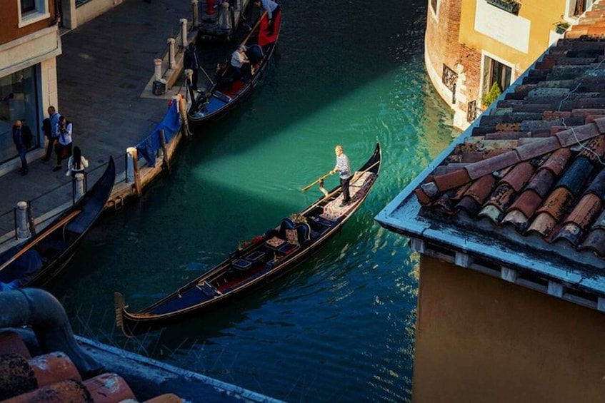 A canal with gondolas, buildings, and a tiled roof. 1