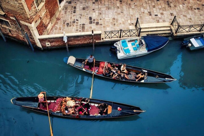 A canal with gondolas docked at the pier. 5