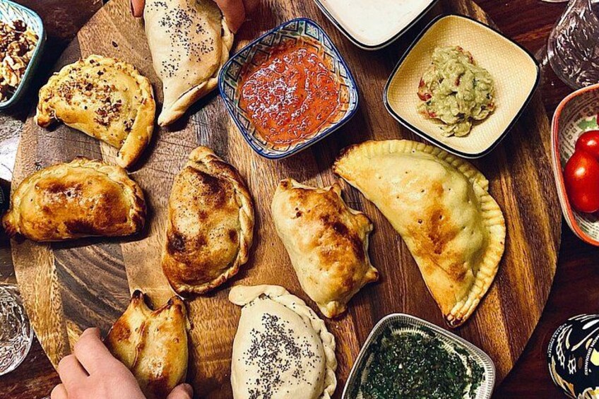 A wooden board with various pastries and dips. 4