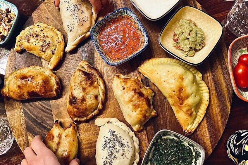 A wooden board with various pastries and sauces. 1