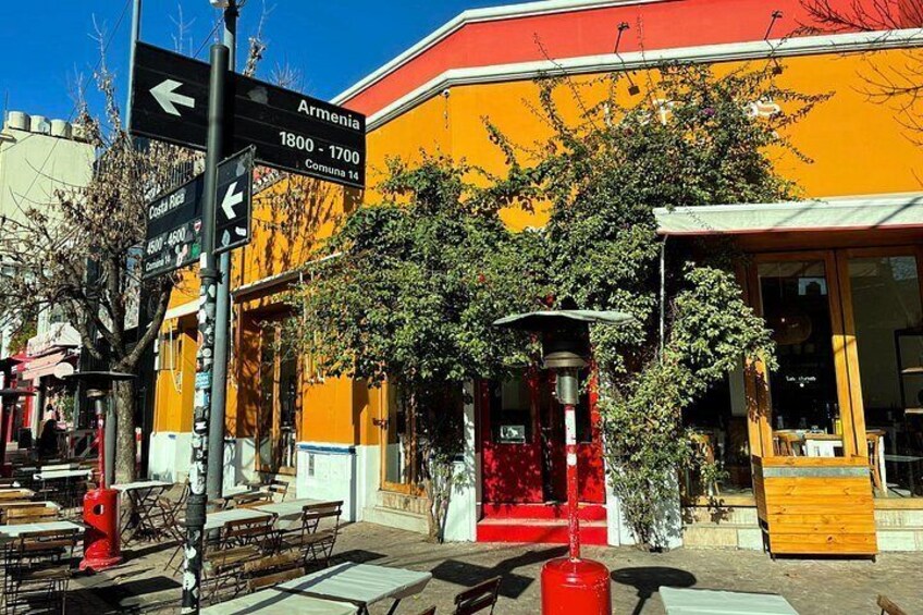 A street with a yellow building, a red fire hydrant, and directional signs. 2