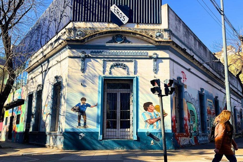 A building with graffiti, a blue door, and a street sign. 5