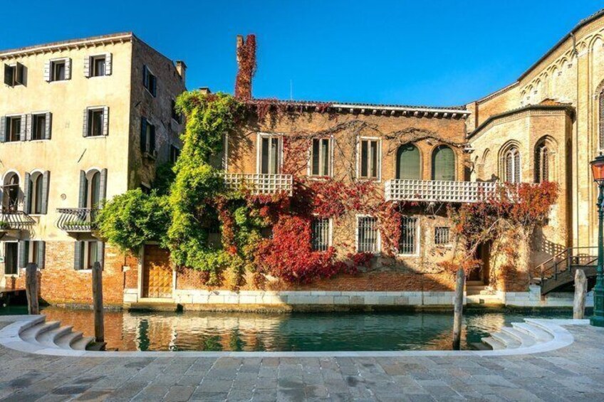 A historic building with arched windows and a fountain in front. 4