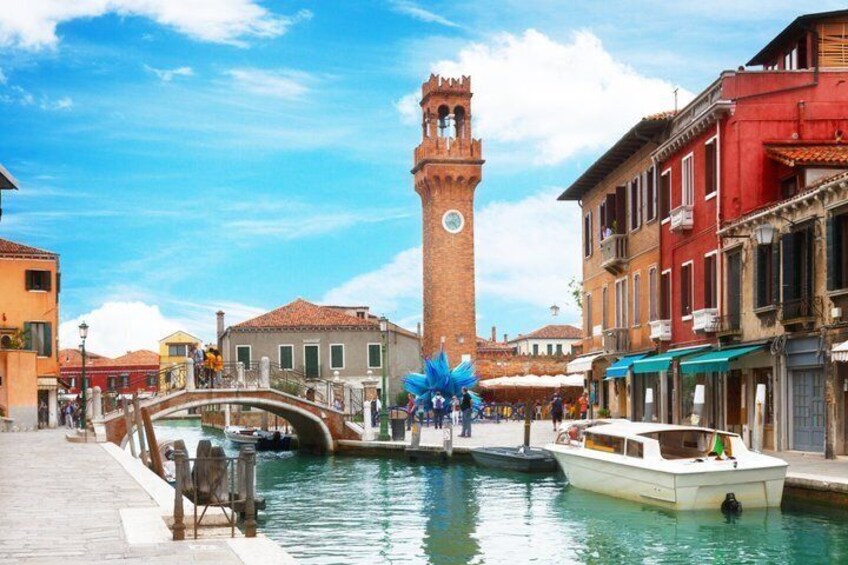 A canal with a boat, a bridge, and a tower. 2
