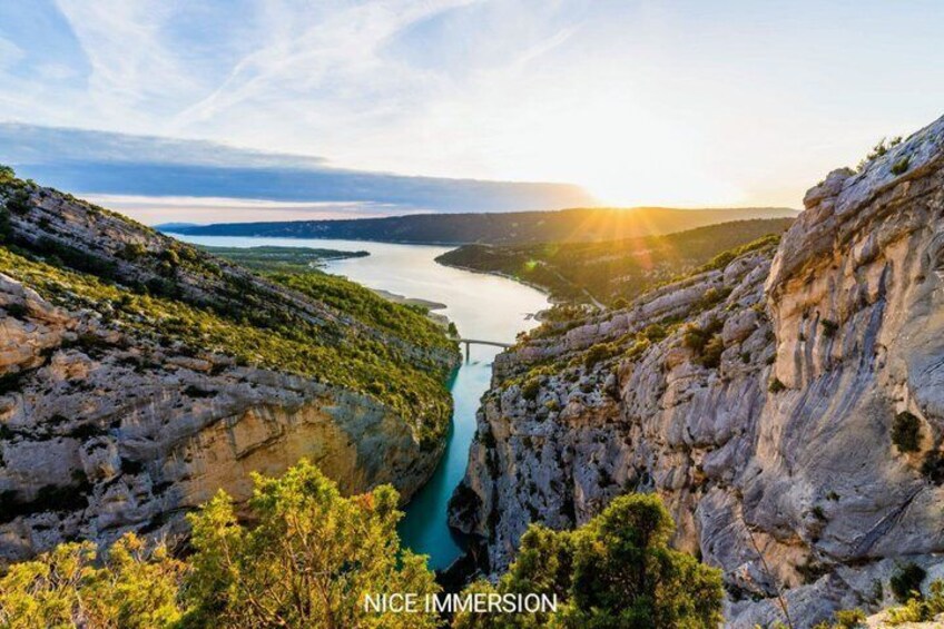 A canyon with a river, rocky cliffs, and a sunset. 1
