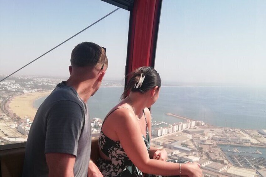 A couple overlooking a coastal cityscape from a high vantage point. 1