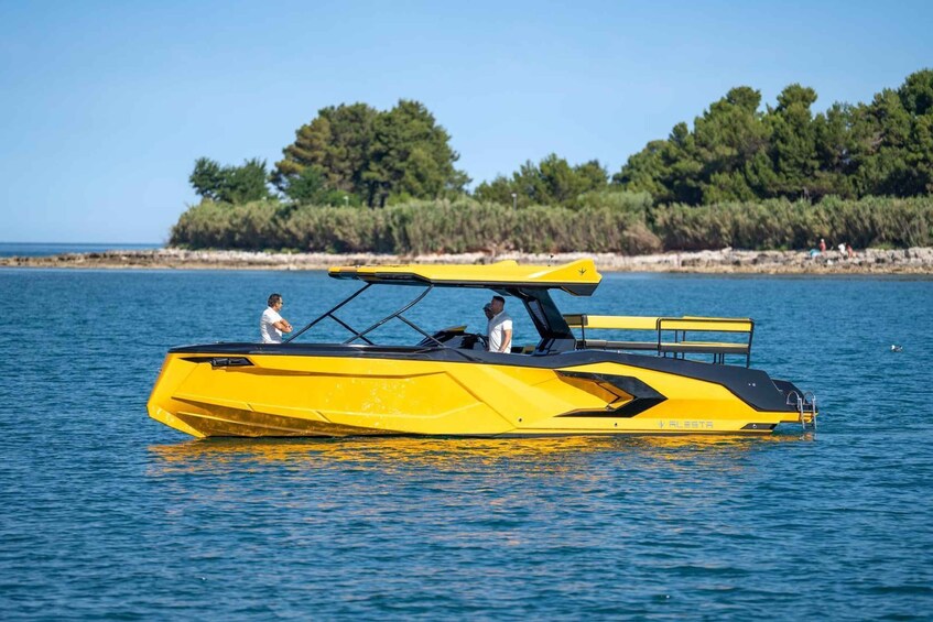 A yellow boat with two people on it, floating on calm water with a forested shoreline in the background. 3