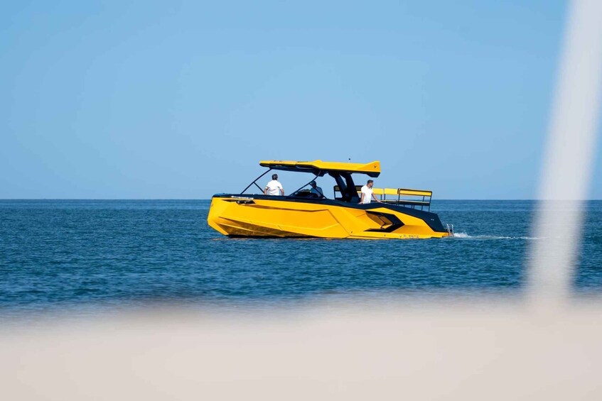 A yellow speedboat with two people on the water. 4