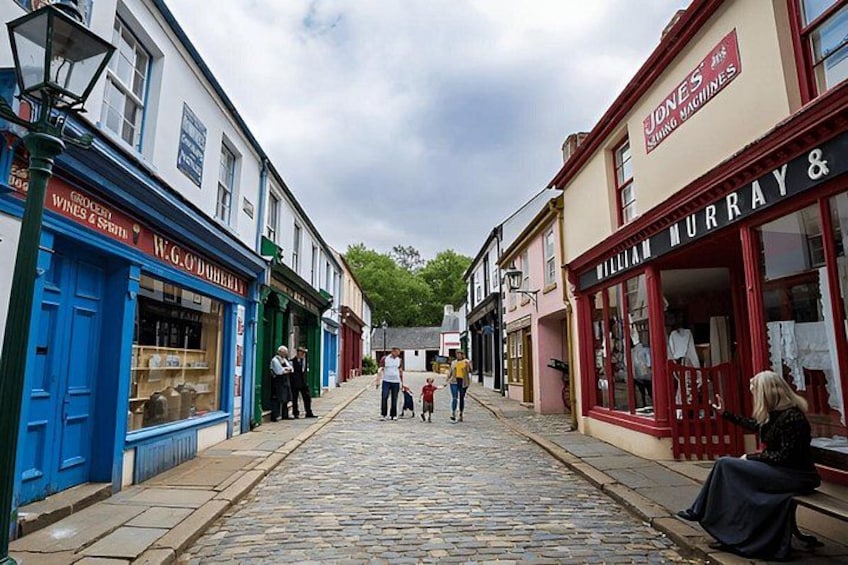 A cobblestone street lined with shops, including a blue storefront and a red one. 4