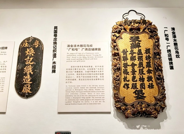 A display of traditional Chinese embroidery with gold accents and calligraphy. 2
