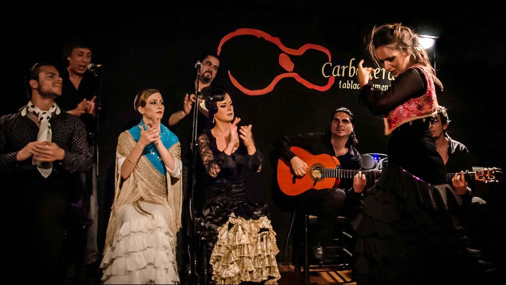 A group of people performing on stage with musical instruments. 2