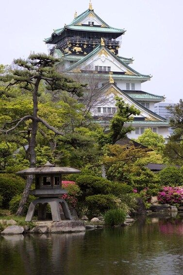 A traditional Japanese castle with a multi-tiered roof, surrounded by lush greenery and a tranquil pond. 3