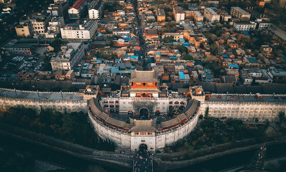 An aerial view of a historic walled city with a prominent circular fortress-like structure in the center. 3