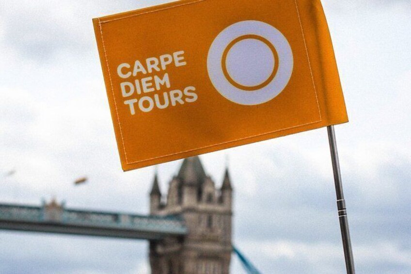 A flag with 'CARPE DIEM TOURS' text and a white circle, set against a cloudy sky with a bridge and a tower in the background. 3