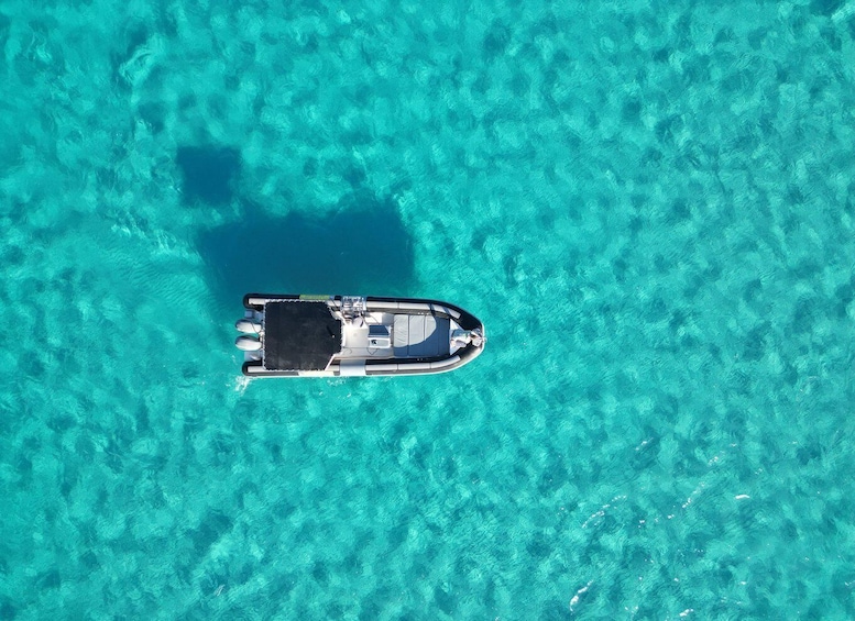 An aerial view of a boat on clear turquoise water. 1