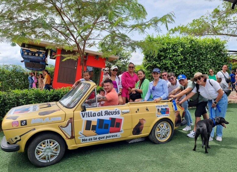 A yellow vintage car with 'Villa al Reus' and a dog illustration, surrounded by people and a dog. 4