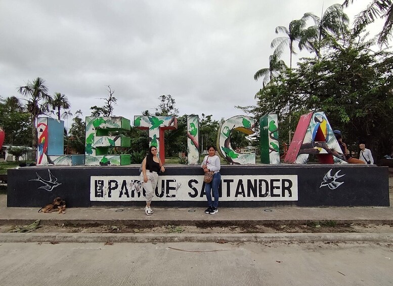 A sign with colorful letters spelling 'PETRINA' and 'PARKE SANTANDER' with a dog and a bird illustration. 1