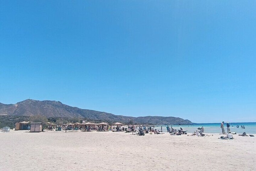 A beach with people sunbathing and a mountain in the background. 5