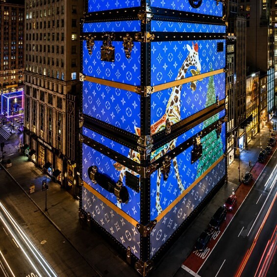 A large, illuminated Louis Vuitton display on a city street at night. 4