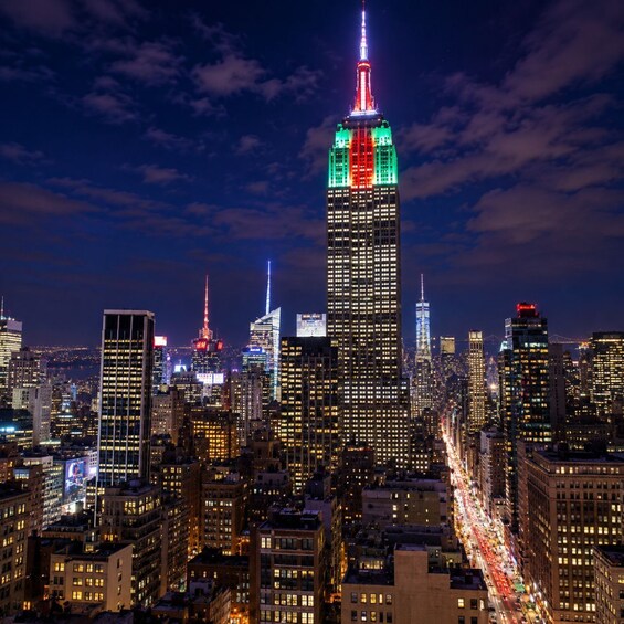 A cityscape at night with a prominent skyscraper lit in red, green, and blue. 2