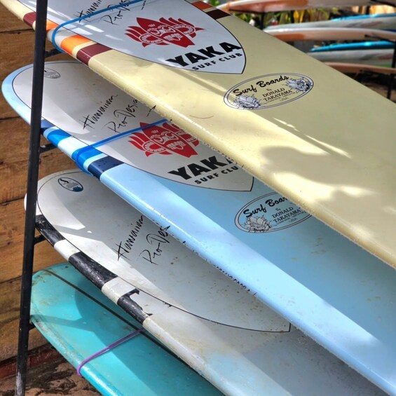 A row of surfboards with 'YAKA SURF CLUB' branding and signatures. 3