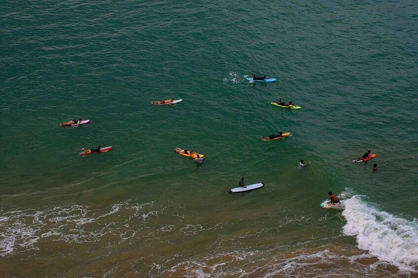 A group of people on surfboards in the ocean. 4