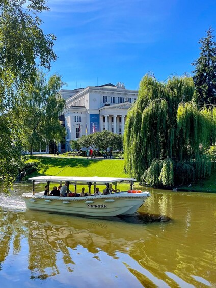A boat named 'Samanta' on a river with a building and trees in the background. 2