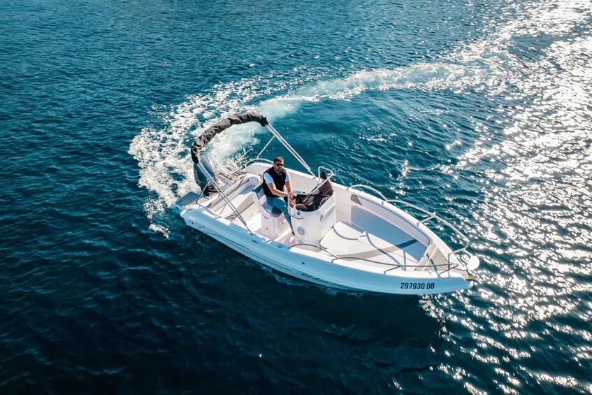 A small motorboat with a person on board, moving through a body of water. 3
