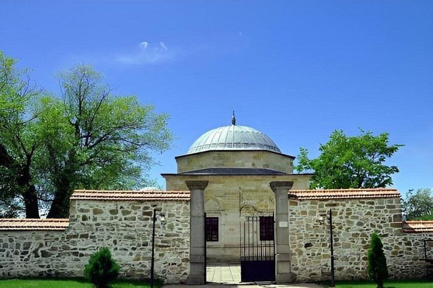 A stone building with a dome and a gate. 5