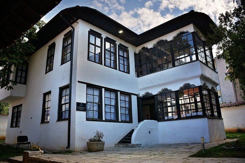 A white building with black trim and multiple windows. 3