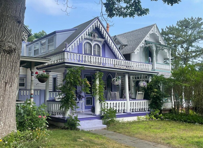 A Victorian-style house with a porch, purple trim, and hanging flower baskets. 4