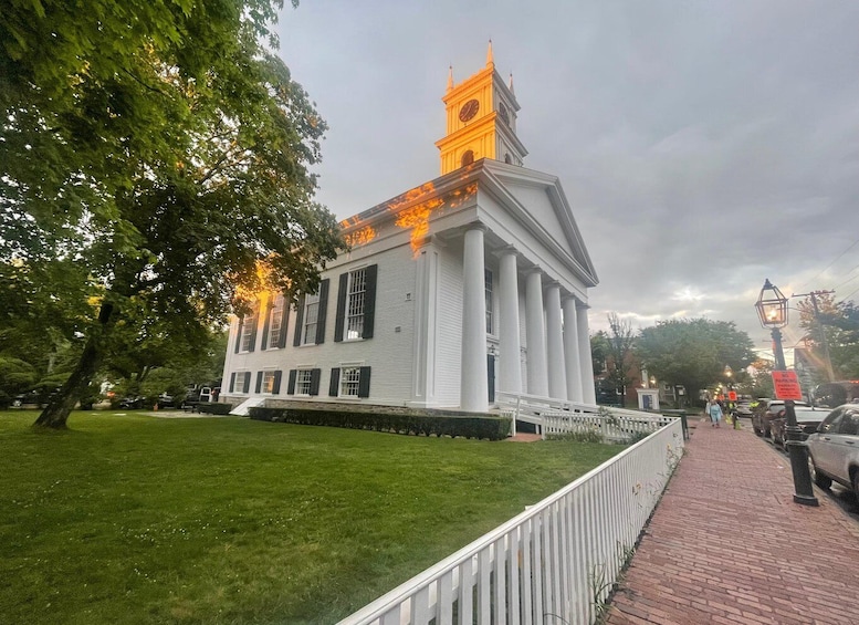 A white building with a clock tower, surrounded by a brick walkway and green grass. 5