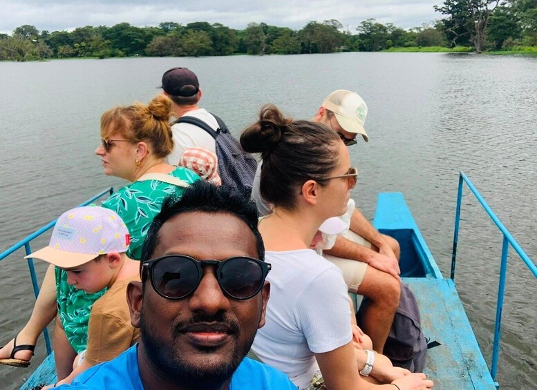 A group of people on a boat on a lake with trees in the background. 5