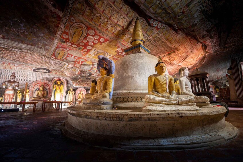 A temple interior with large Buddha statues and intricate ceiling artwork. 4