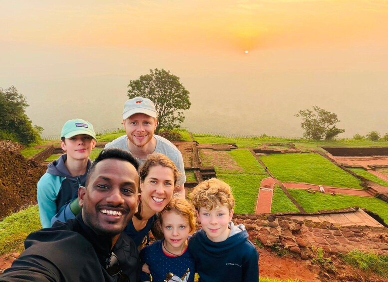 A family posing with a sunset in the background. 1